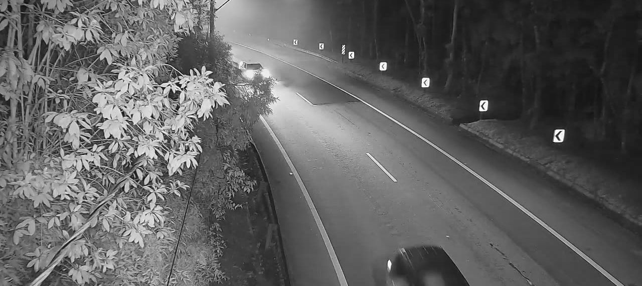 Mesmo trecho de serra à noite, com neblina