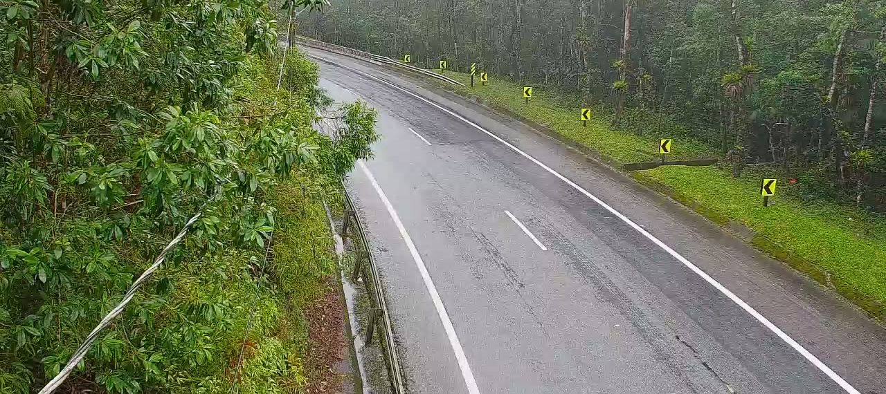Trecho de serra com curva e pista molhada